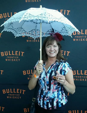 Kristen from ACityDiscount at Food Festival with glass of whiskey and parasol
