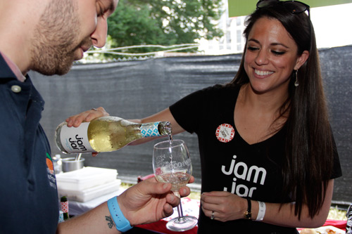 A woman pours white wine for an ACityDiscount employee at the 2015 Atlanta Food & Wine Festival.
