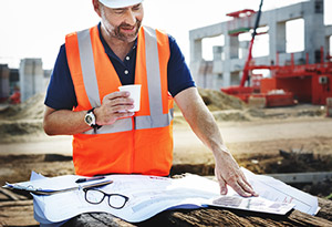 Construction worker pauses working for a drink of cold water.