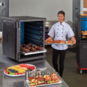 Caterer loads food into a Cambro GoBox insulated carrier to be transported to an event.