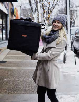 A young woman holds a Cabro GoBag with takeout in the cold.